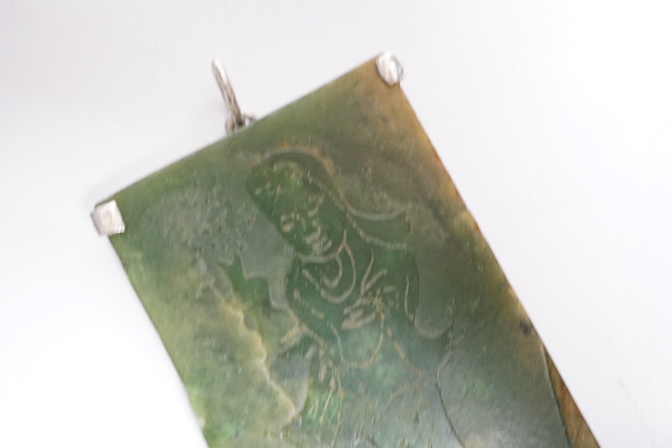A Chinese carved spinach green jade panel, 9cms high.